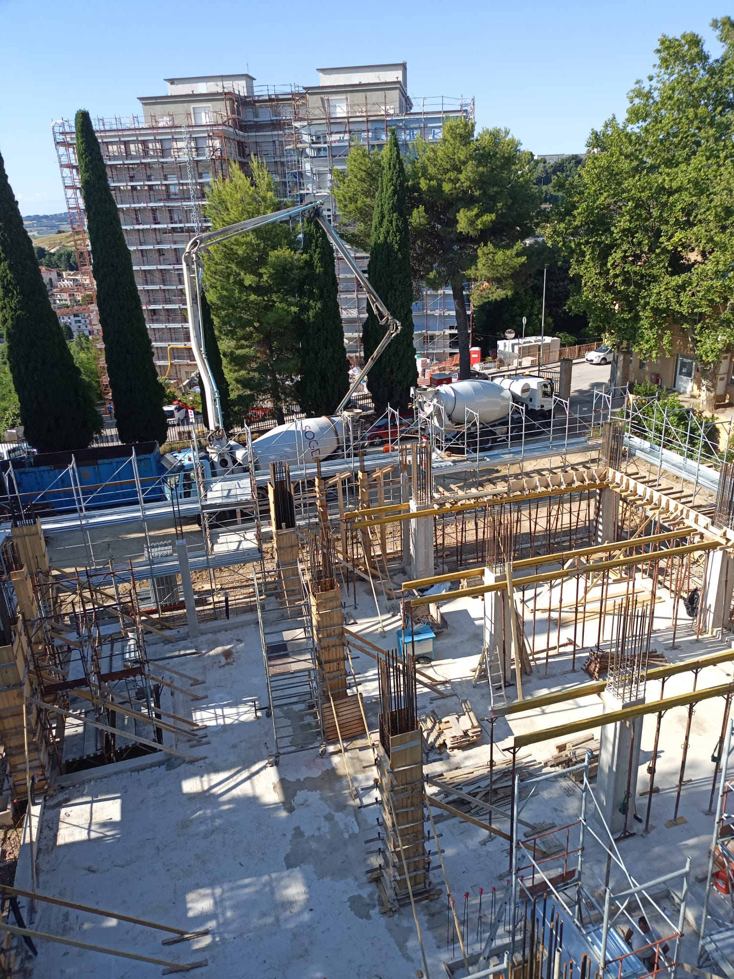 Vista del cantiere della Casa della Comunità di Loreto con pilastri, casseforme e mezzi per il calcestruzzo